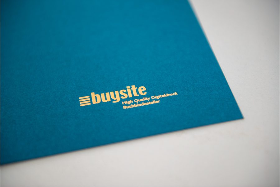 Das buysite-Logo, in Gold auf petrolfarbenem Karton heissfoliengeprägt